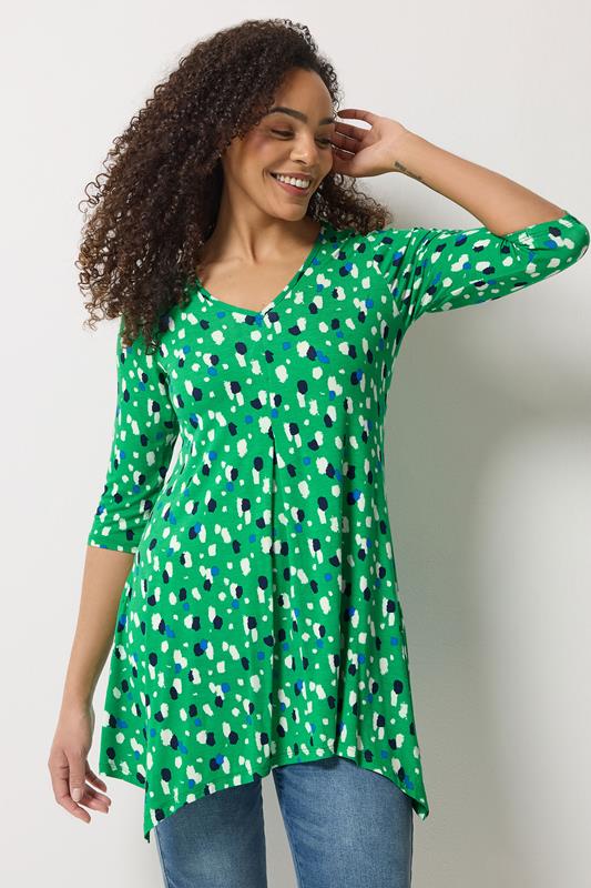  M&Co top con bajo asimétrico y marcas verdes