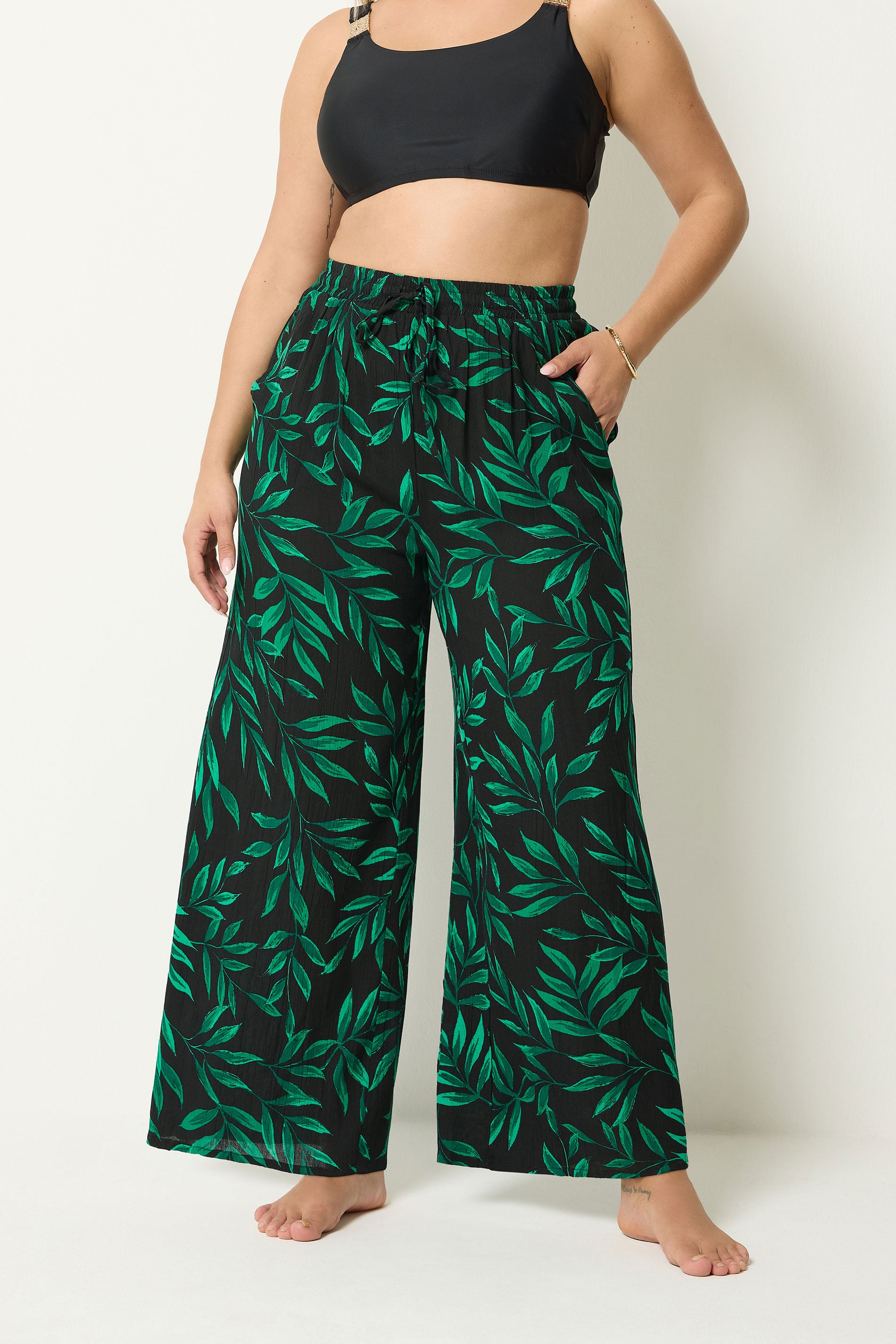 YOURS Plus Size Black & Green Leaf Print Crinkle Beachwear Wide Leg Trousers | Yours Clothing 1